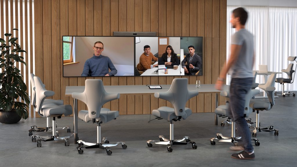 Neat Bar mounted above two monitors in a conference room.